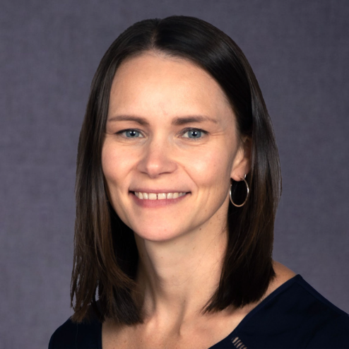 Windy Wilkins, Leadership Consultant & Coach — woman with straight dark brown hair in a navy top on a grey background