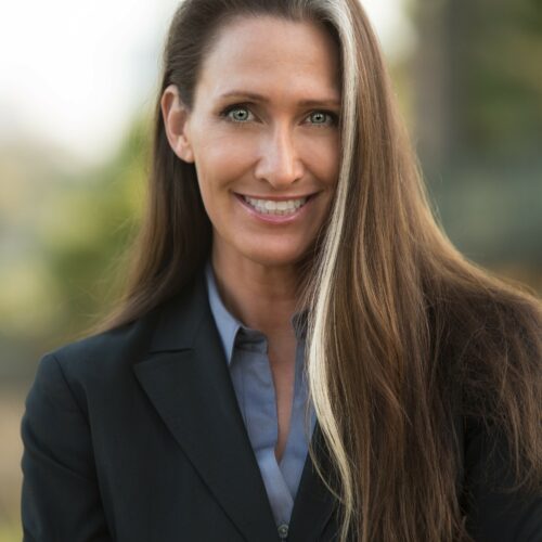JoAnne Foist, PhD, Leadership Consultant & Coach — woman with long brunette and blonde-streaked hair in a black blazer