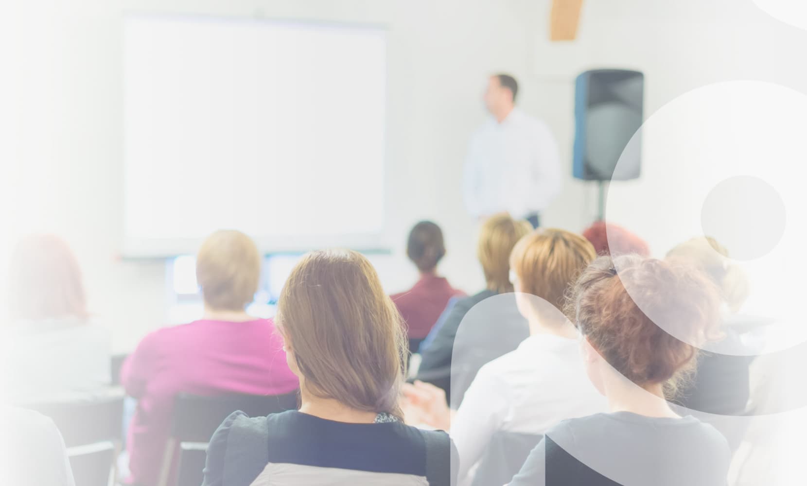 Audience watching a presenter at a coaching seminar