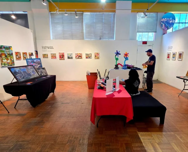 Instagram post: gallery interior with colorful paintings and artist vendor tables at a Collab event