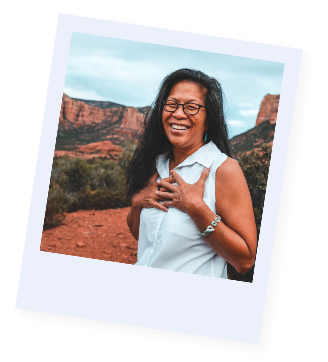 Wendy Moomaw laughing with her hands over her heart in the desert