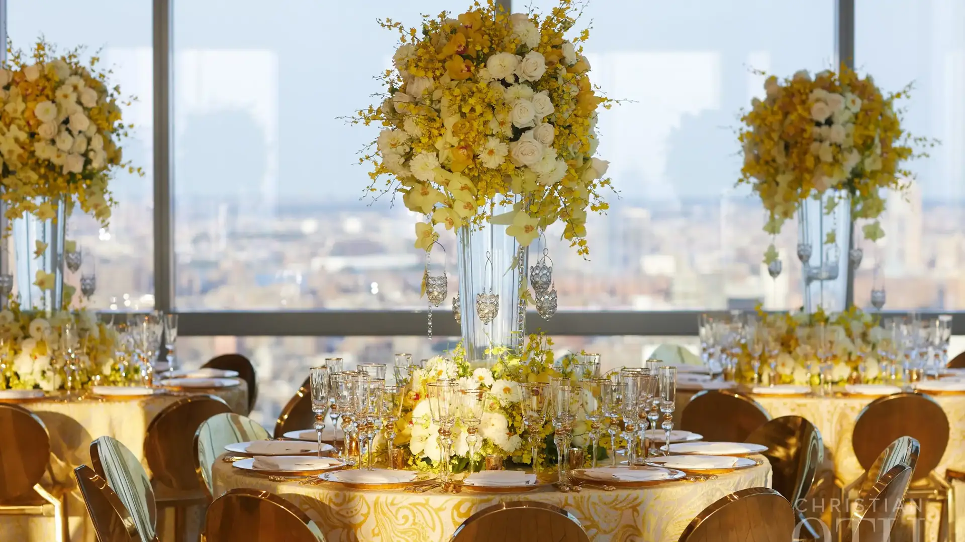 Luxury high-rise wedding reception with yellow orchid centerpieces and the NYC skyline through floor-to-ceiling windows