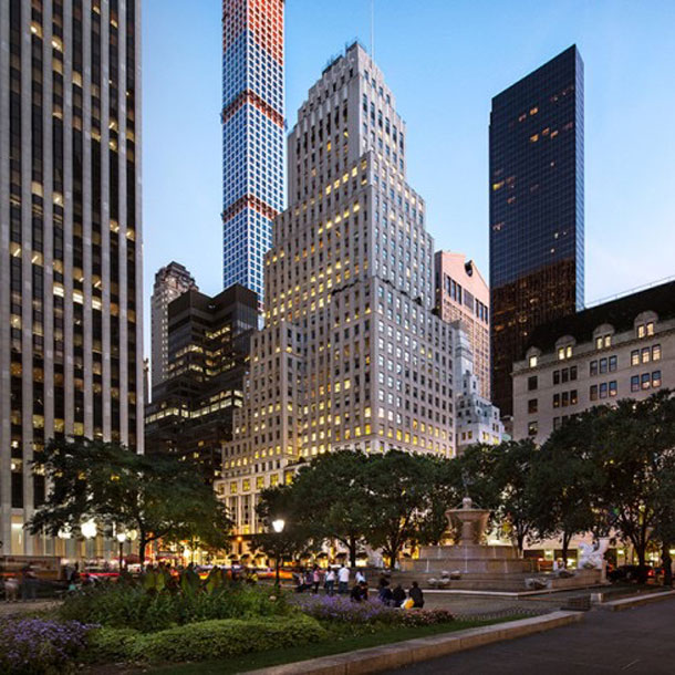 Midtown Manhattan skyline at dusk with skyscrapers and a park plaza