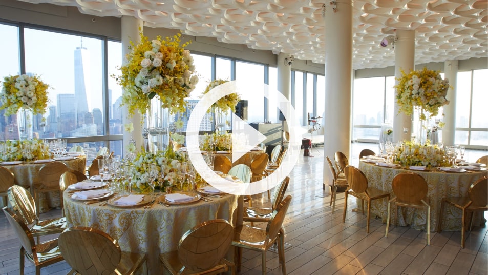 NYC high-rise wedding reception with yellow floral centerpieces and a One World Trade Center view
