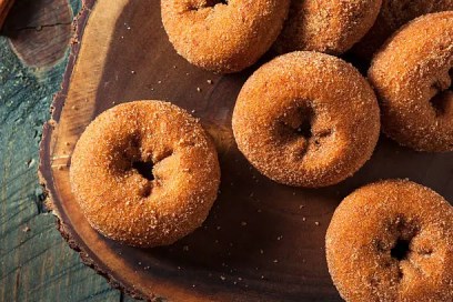 Cinnamon-sugar apple cider donuts on a wooden board