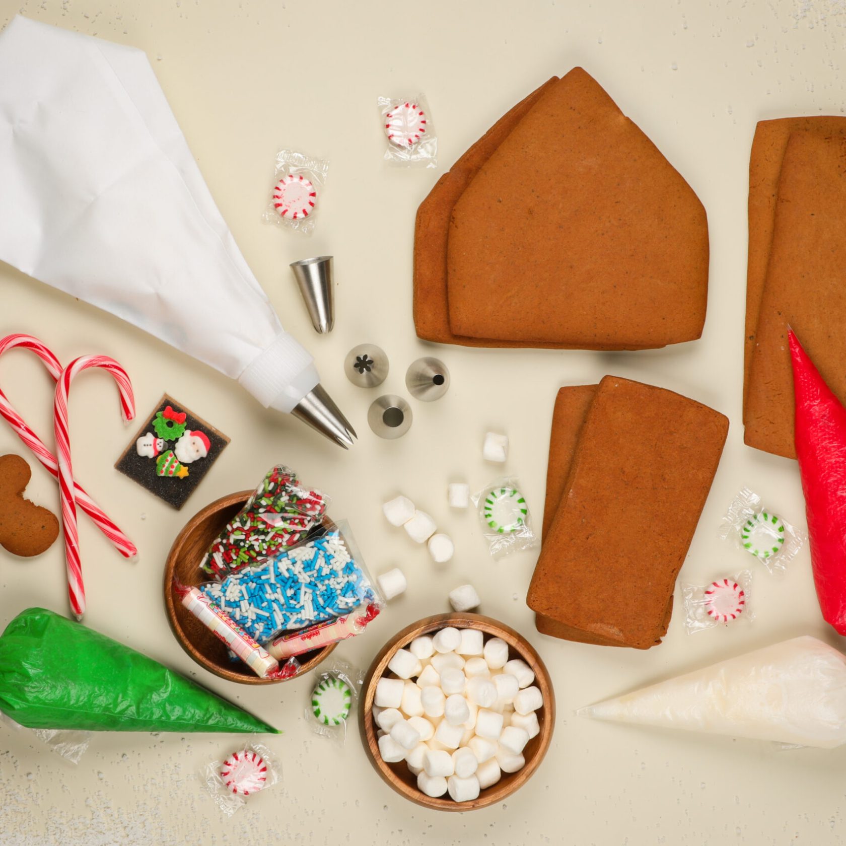 Gingerbread house kit pieces, icing bags, candy canes and marshmallows