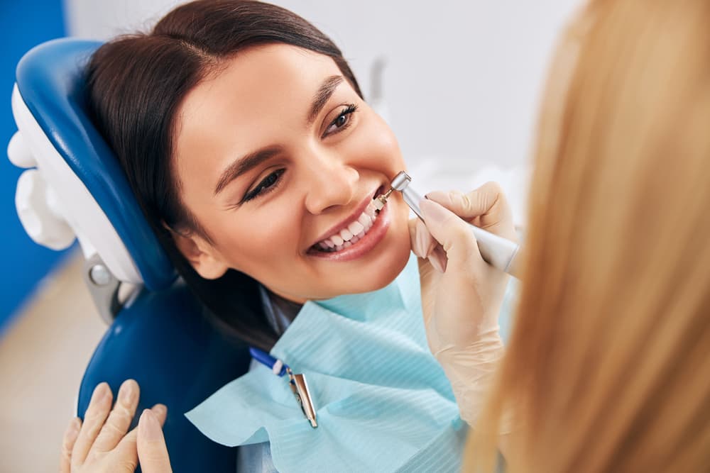 Patient smiling in a dental chair during a teeth cleaning