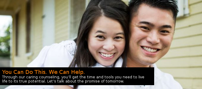 Young couple smiling outdoors in front of a house, captioned “You Can Do This. We Can Help.”