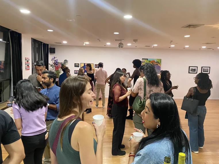 Art House party guests mingling in a studio hung with artwork