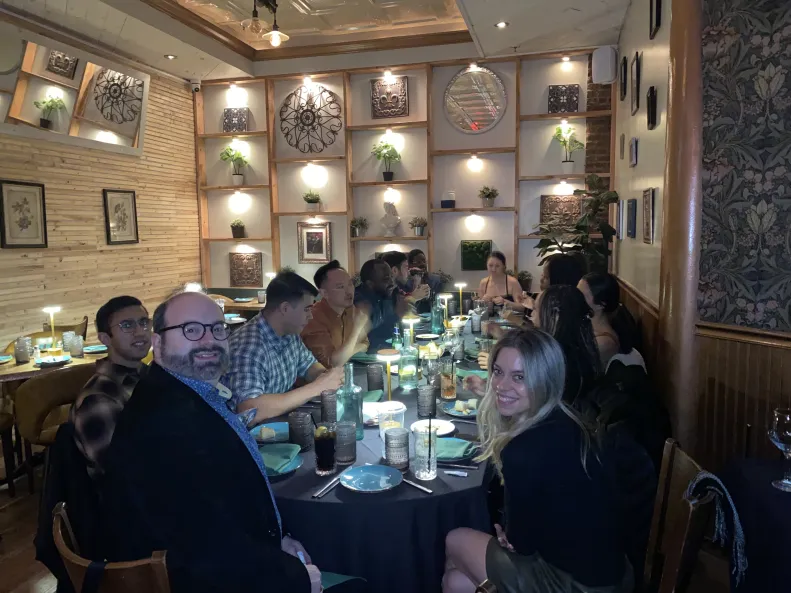 Guests around a table in a warmly lit, decorated private dining room at an Art Date Night