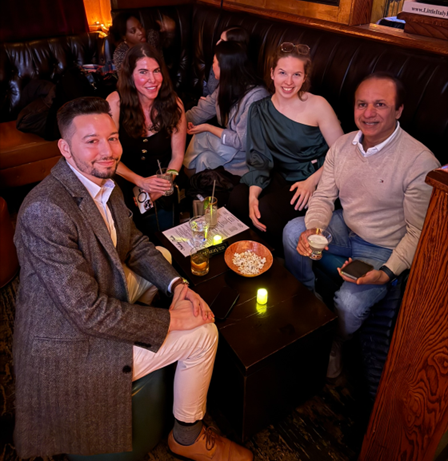 Four Early Burdz industry mixer guests seated at a table in a dim bar