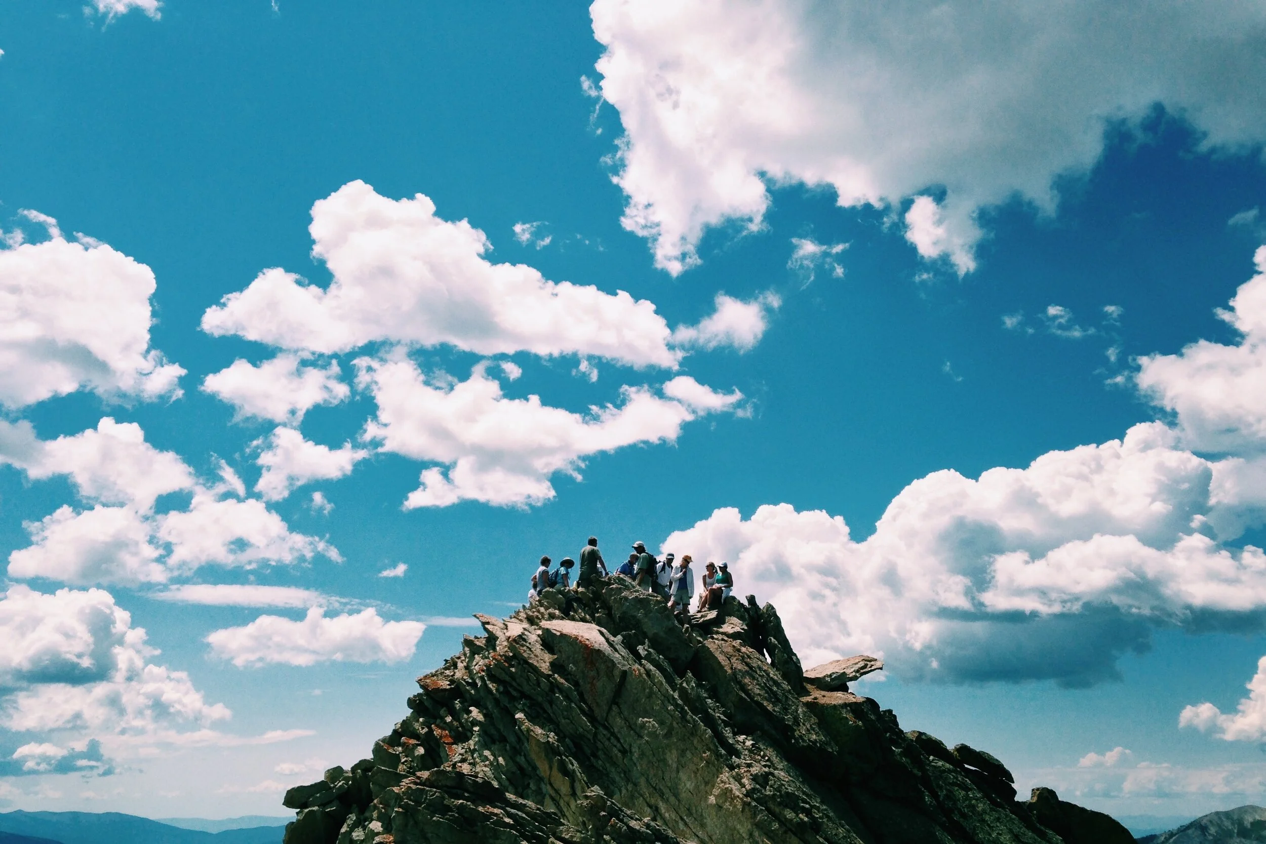 Hikers standing together on a rocky mountain summit