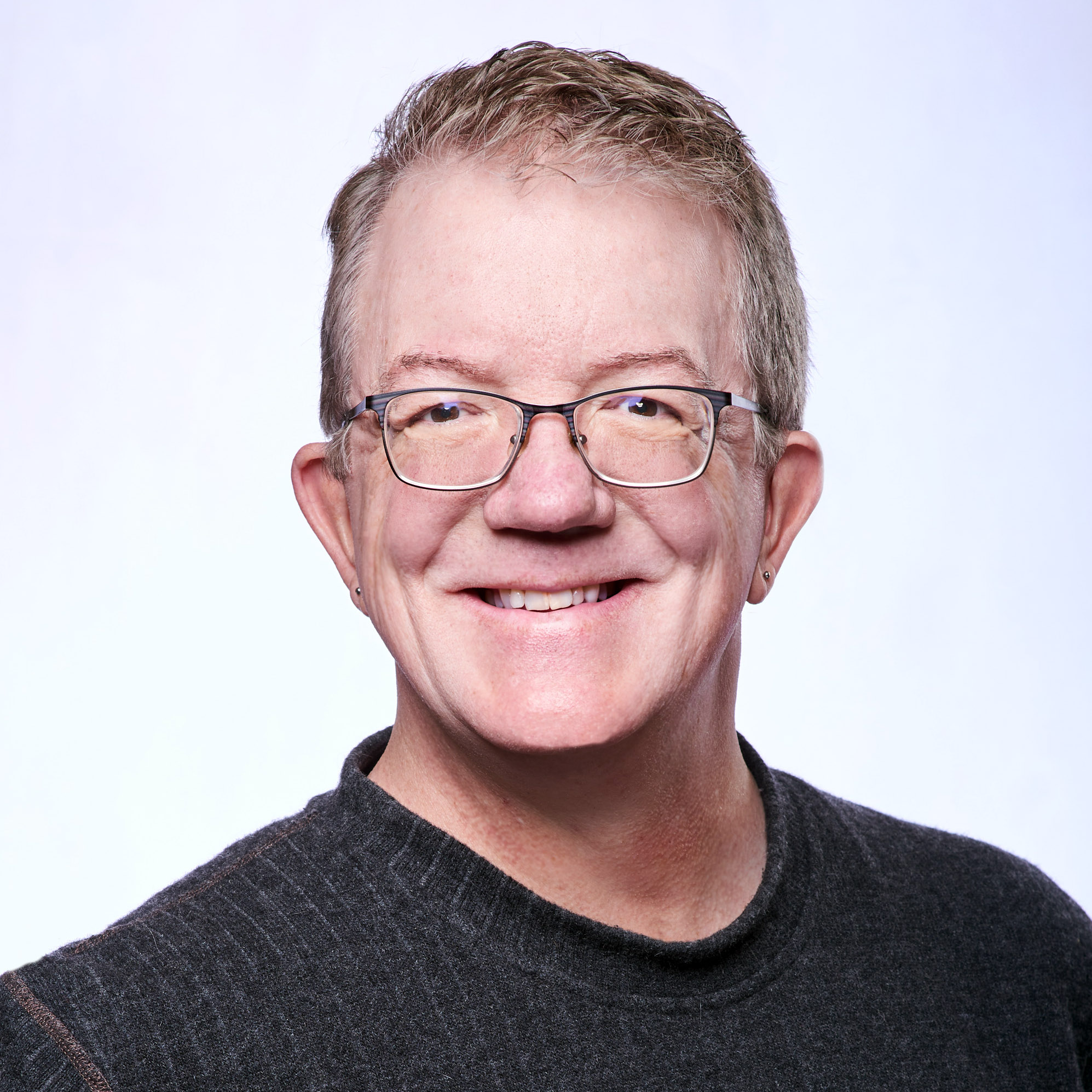 Matt McLaughlin, Inner Peace Leadership Coach — smiling, wearing glasses and a dark sweater