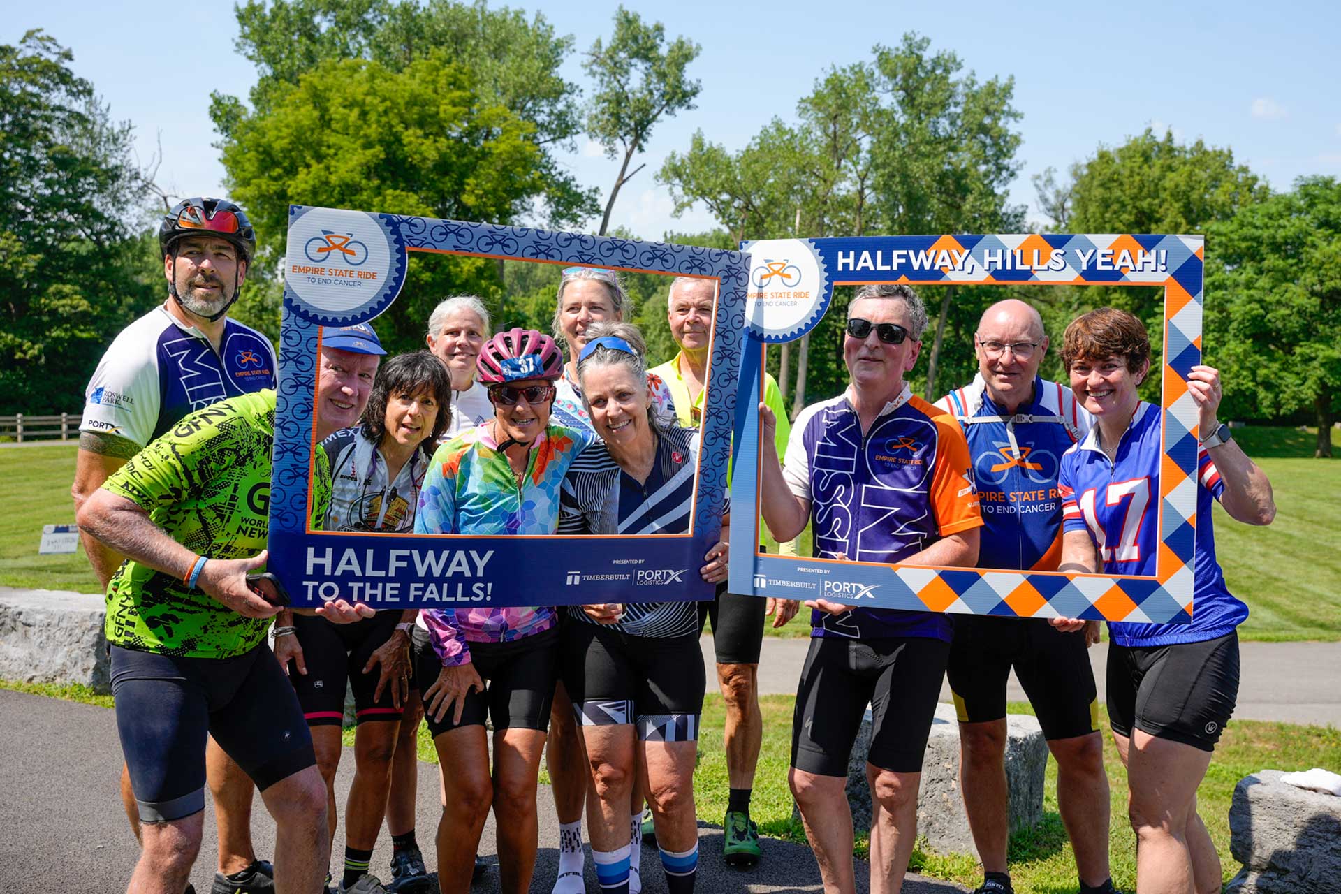 Riders holding branded frames reading Halfway to the Falls
