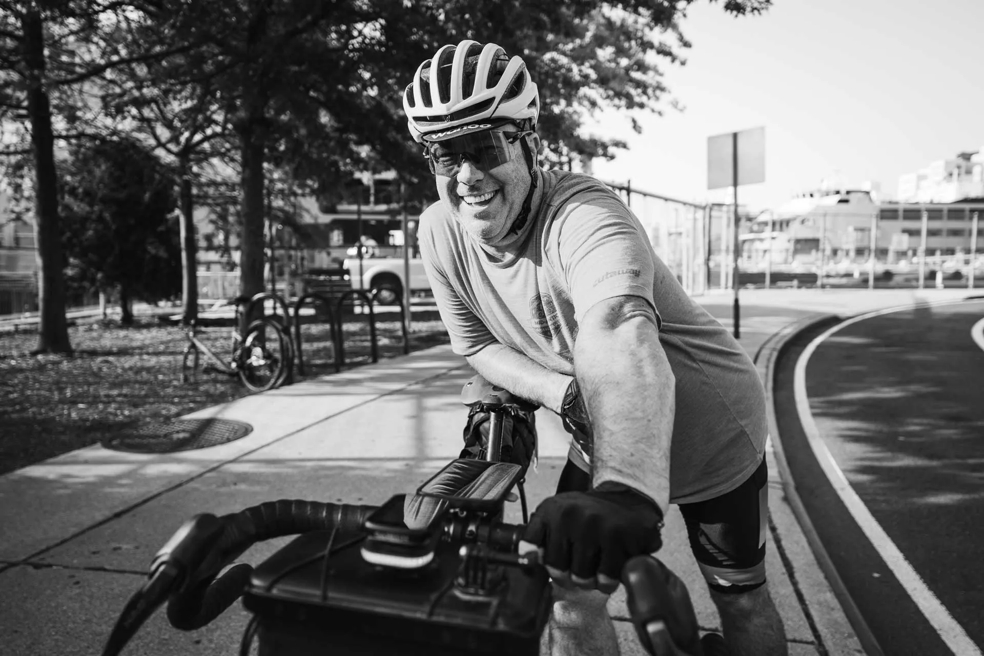Smiling cyclist leaning over handlebars on a bike path