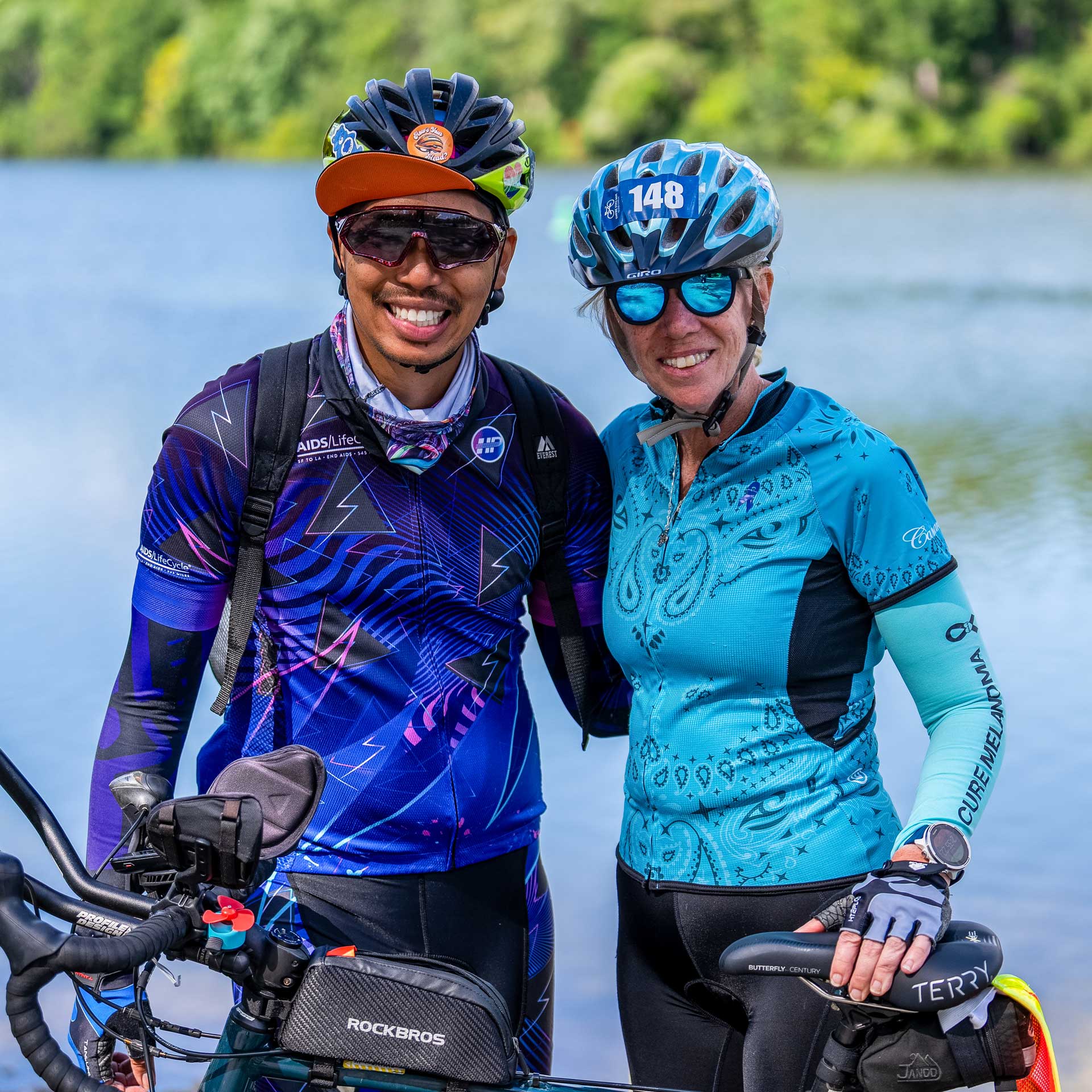 Two Empire State Ride cyclists posing together beside a lake