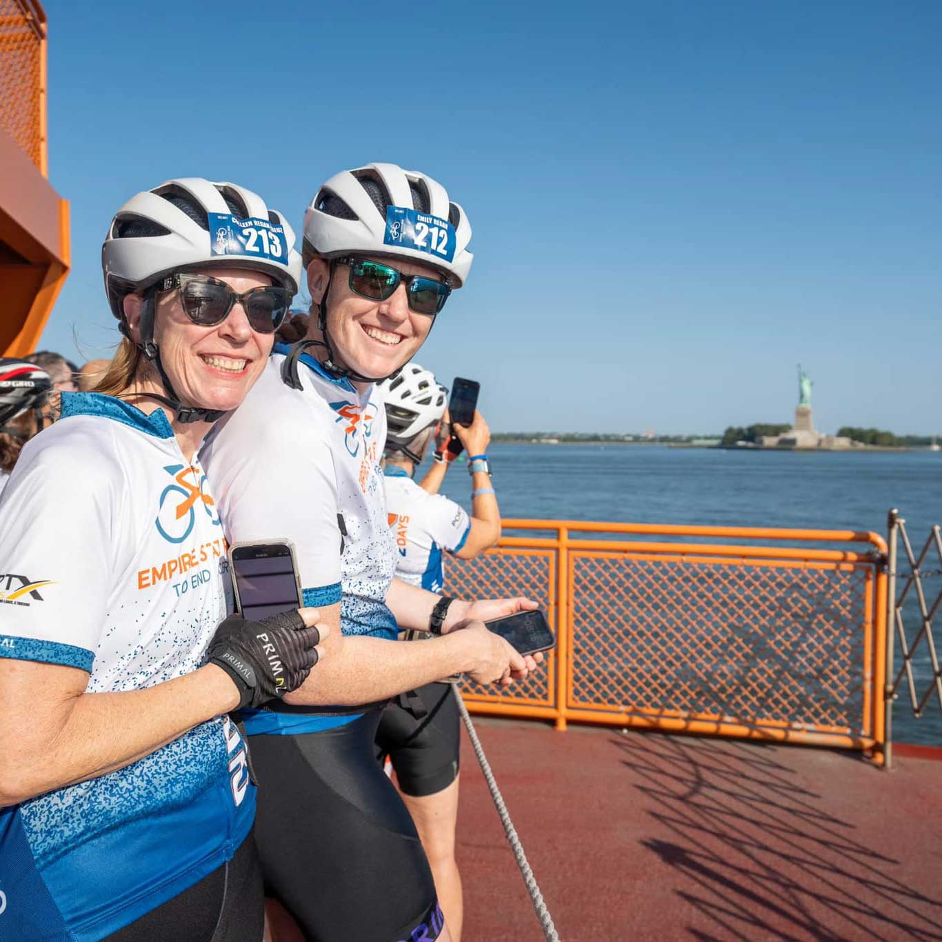 Two riders photographing the Statue of Liberty from the Staten Island Ferry