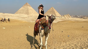 Woman on a camel in front of the Giza pyramids