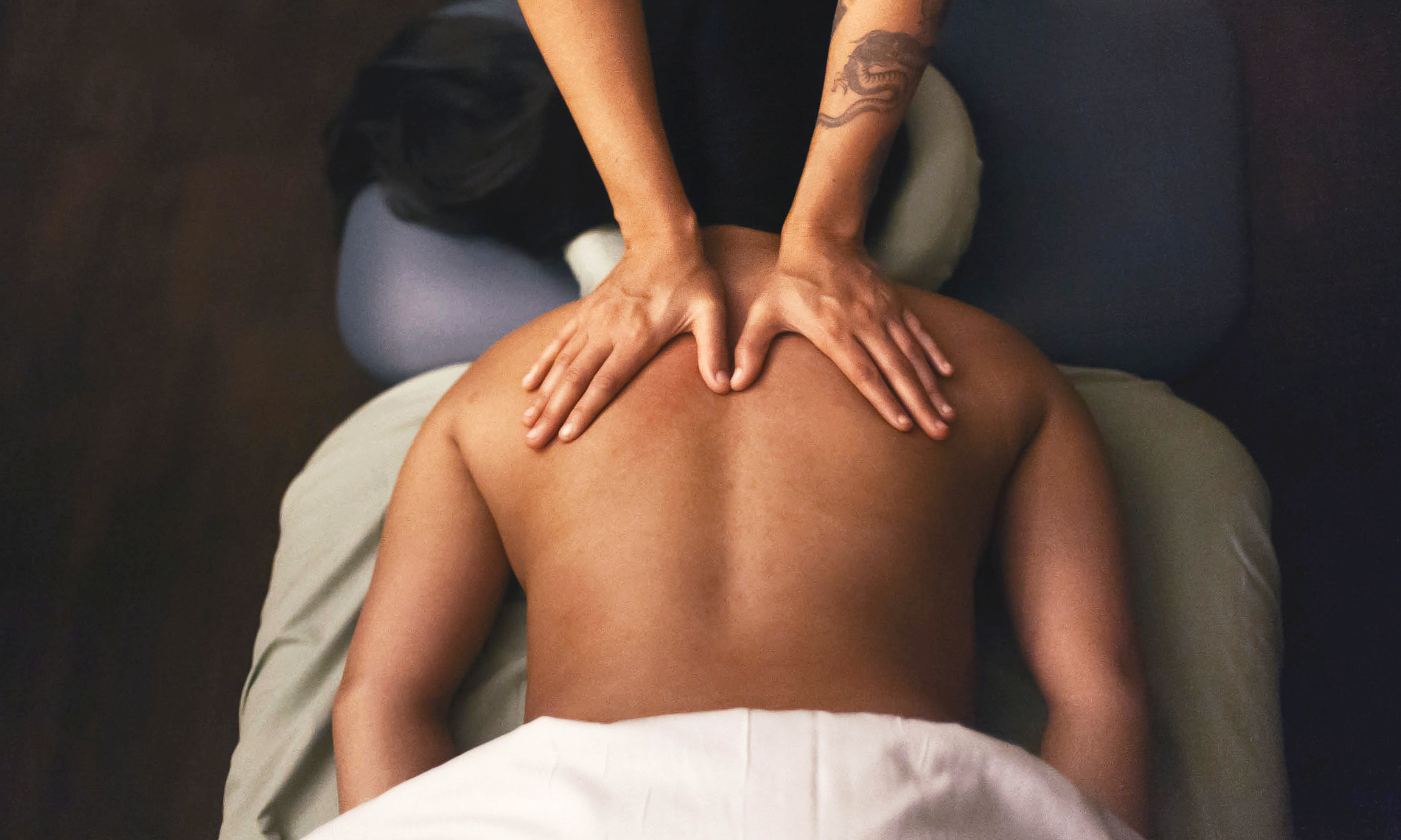 Overhead view of a therapist performing a back massage on a treatment table