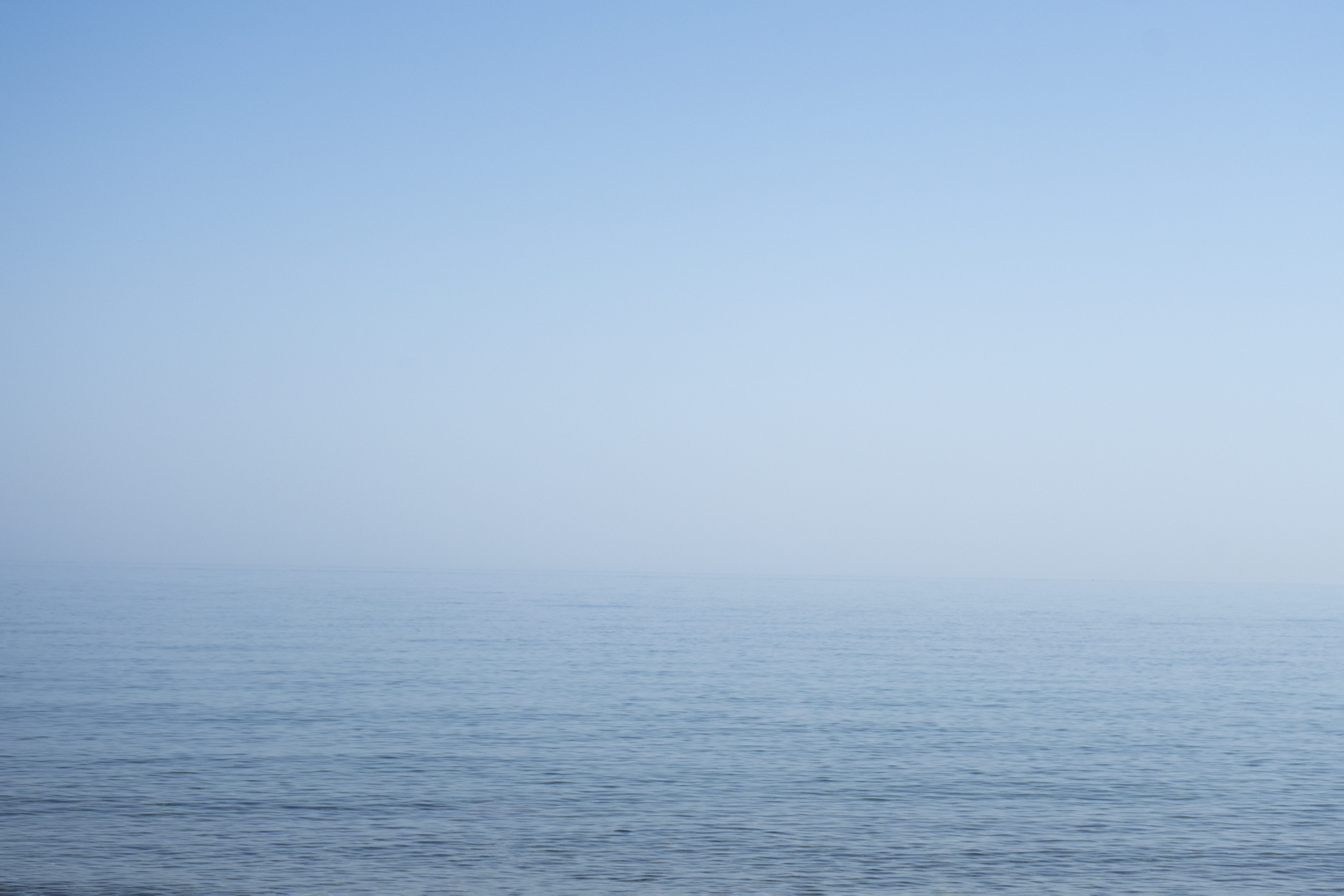 Misty open ocean meeting a pale horizon
