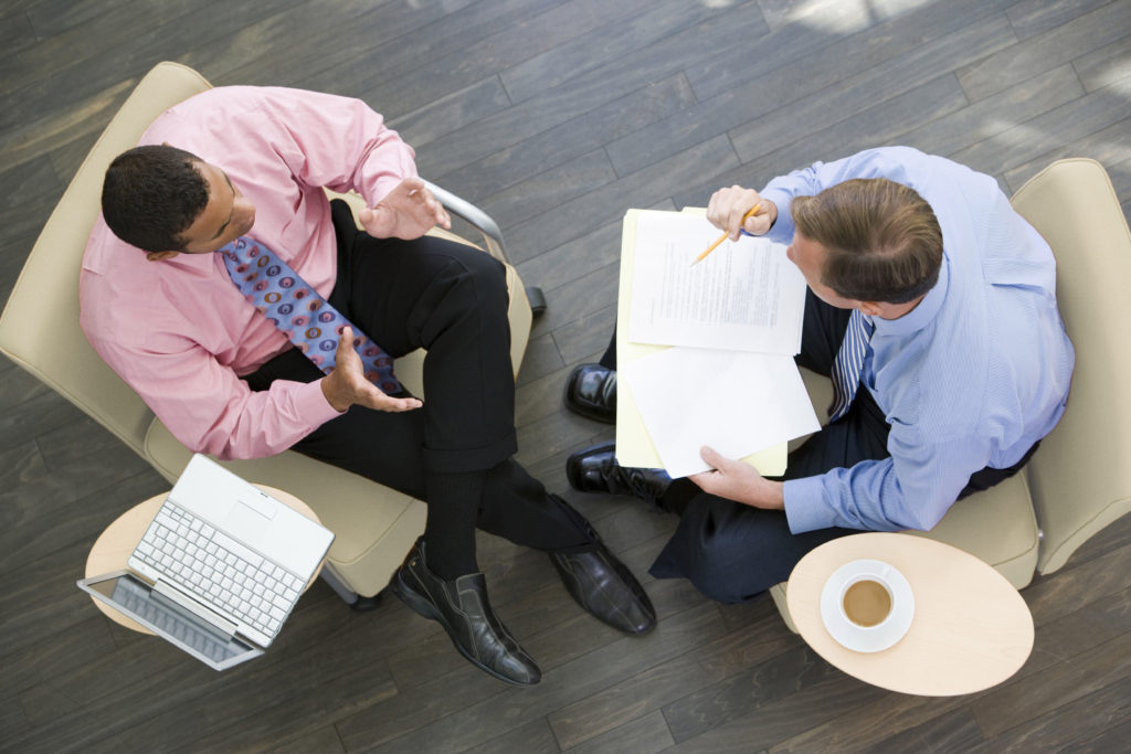 Two businessmen in a coaching session, seen from overhead