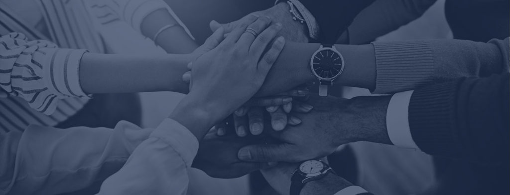 Diverse hands stacked together in a team-unity gesture