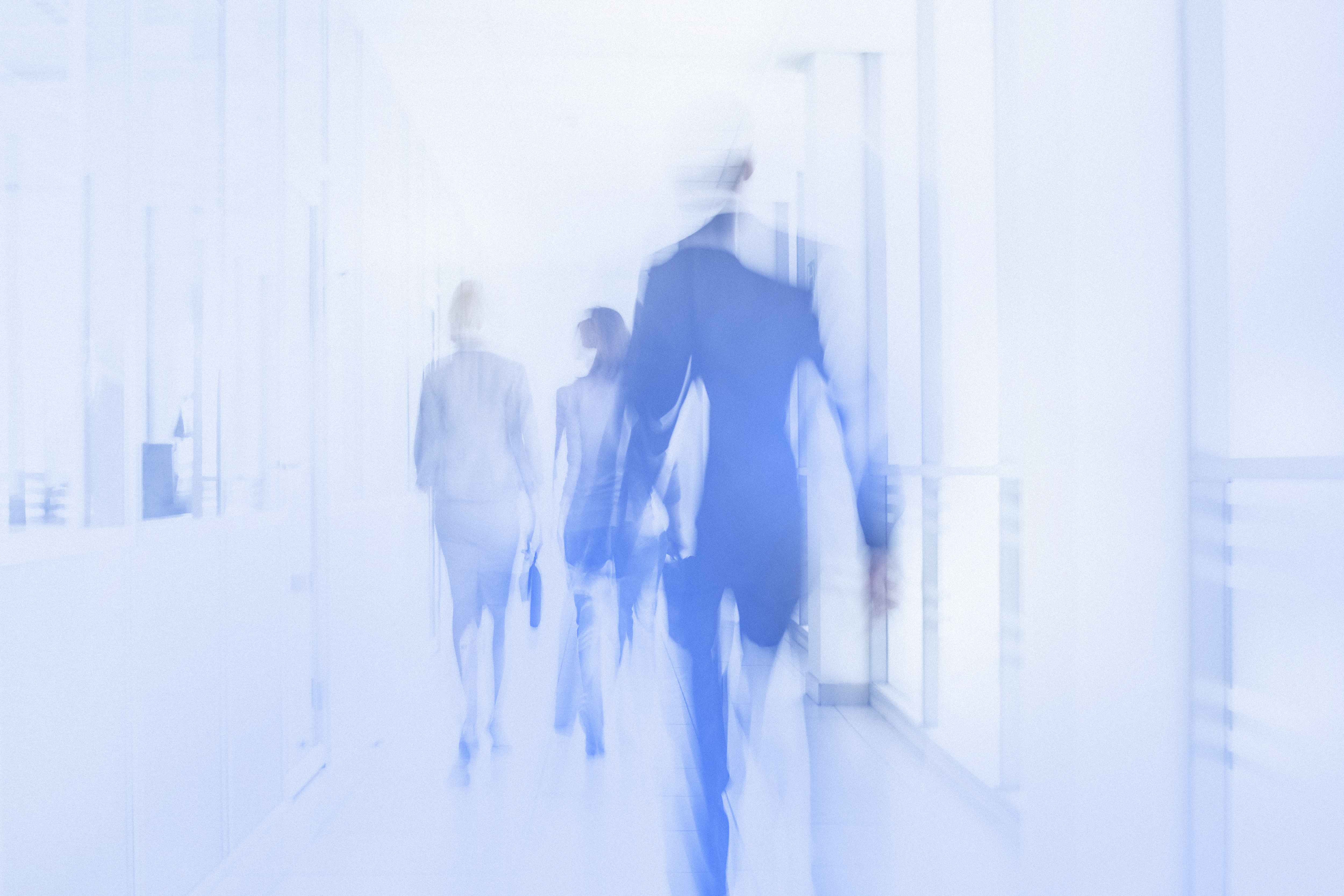 Business professionals walking through a bright modern office corridor