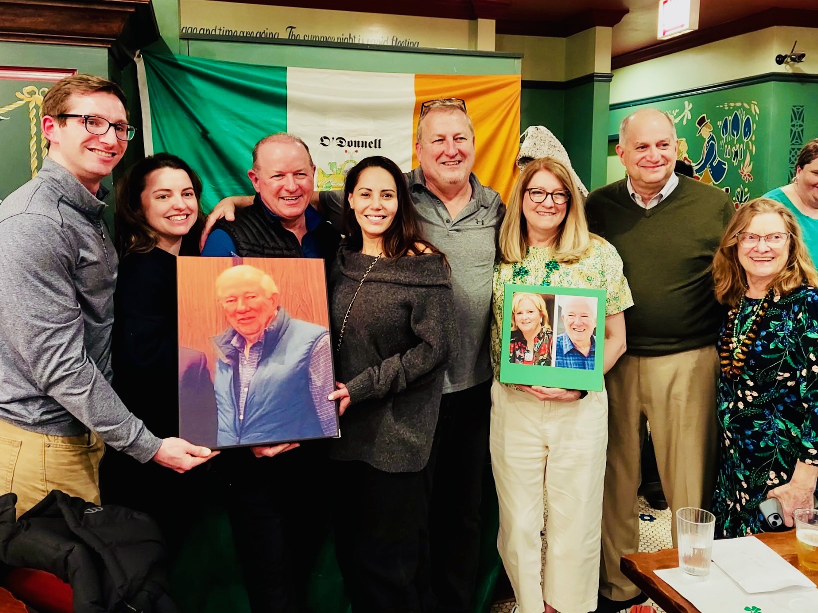 Guests at The Eventors St. Patrick's Day event holding framed portraits with an Irish flag at Ann Sather