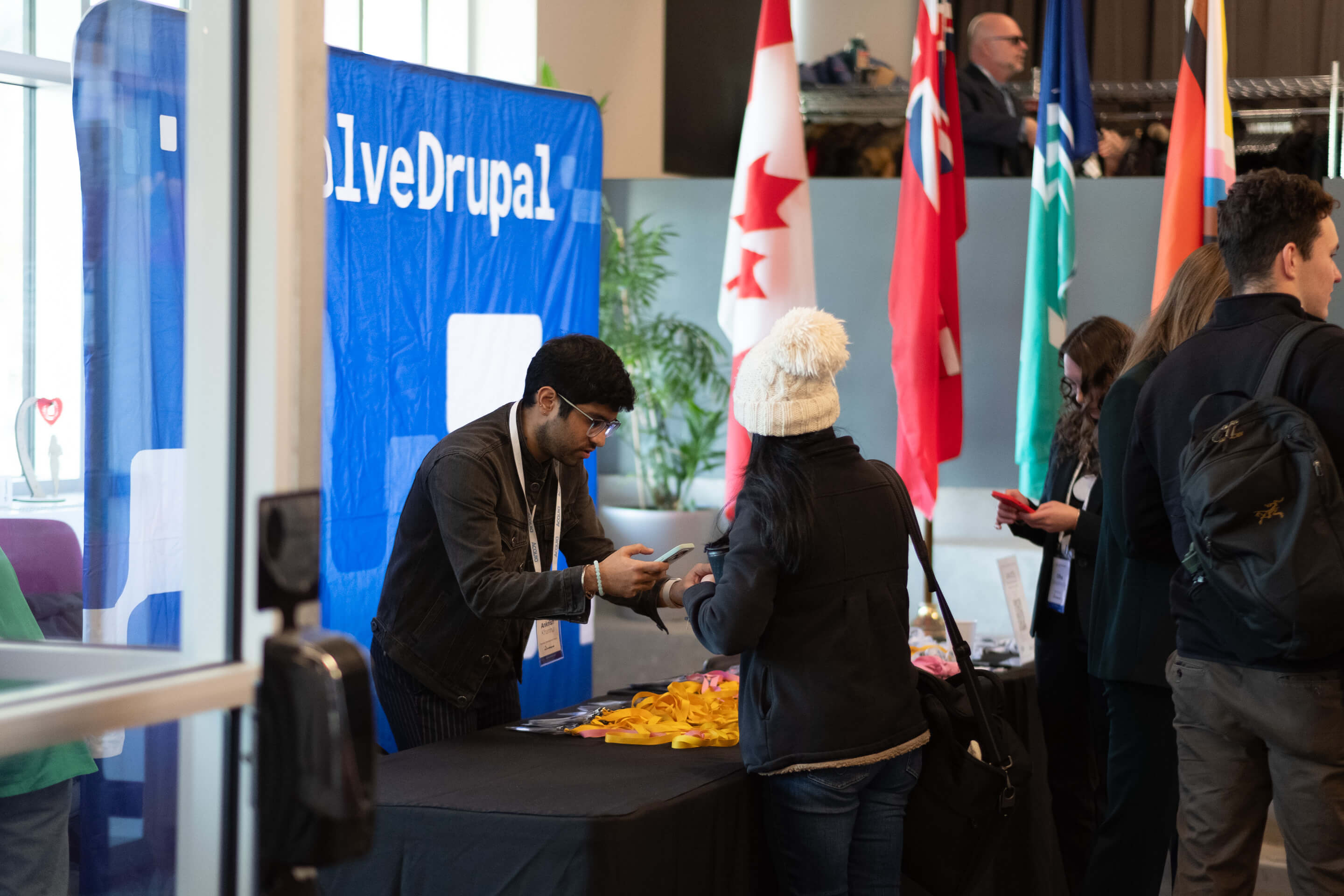Attendee receiving a badge at the EvolveDrupal registration desk in Ottawa