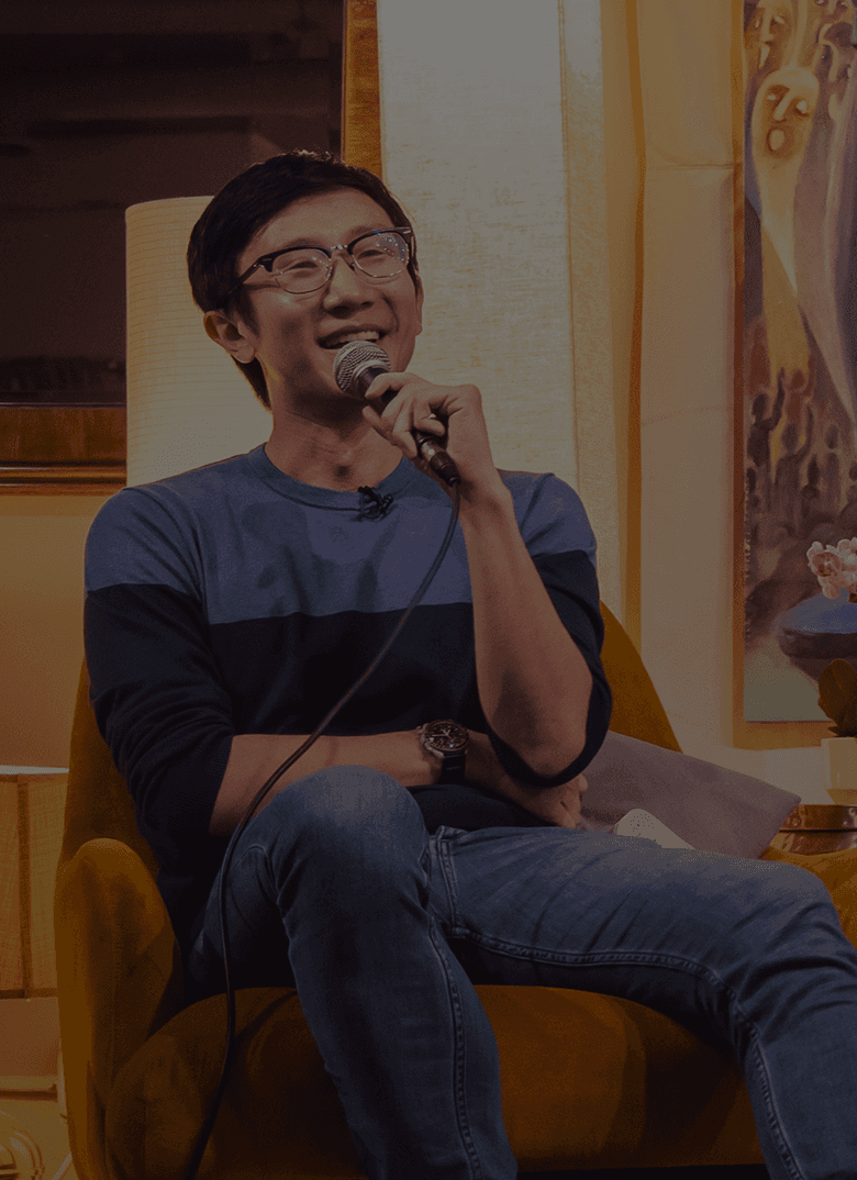 Speaker mid-sentence with a handheld microphone at an Eyes Up event.