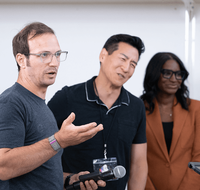 Eyes Up founder briefing a client team with a microphone in hand.