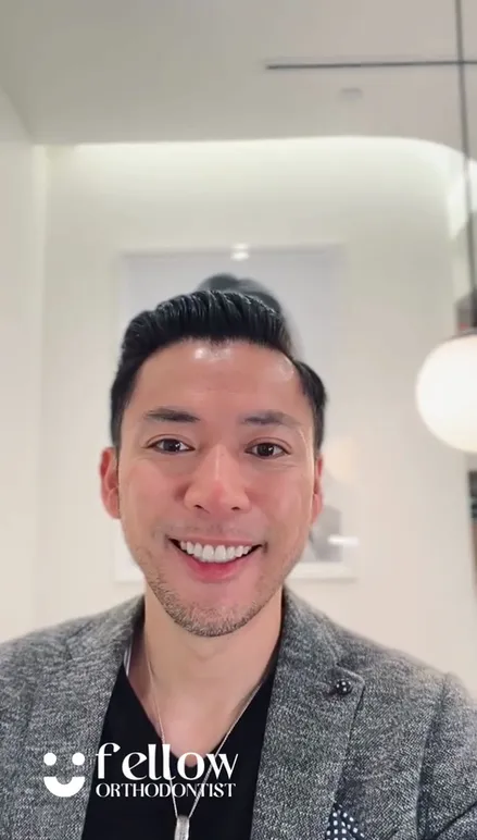Dr. Tony Lin smiling in a grey blazer during a virtual consultation