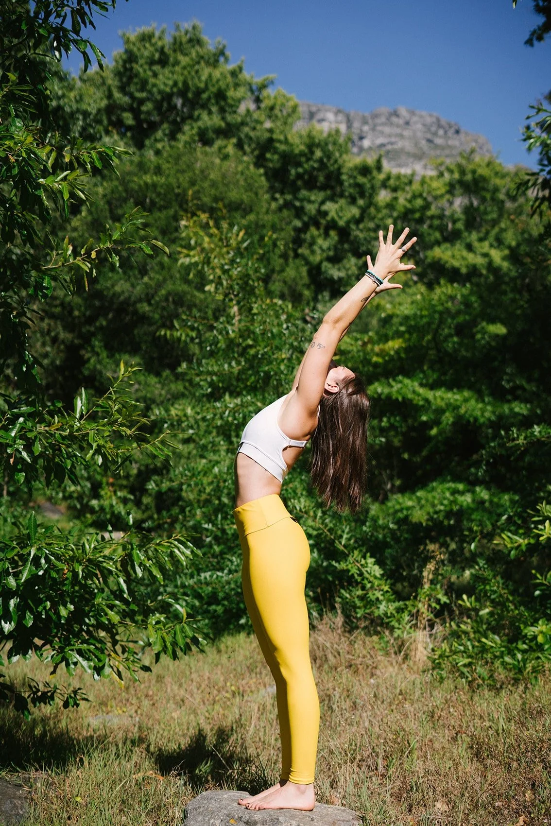 Woman stretching in a lush forest
