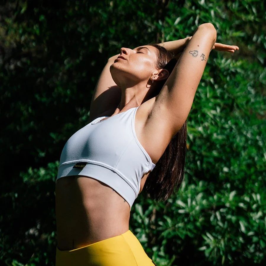 Woman stretching outdoors in greenery