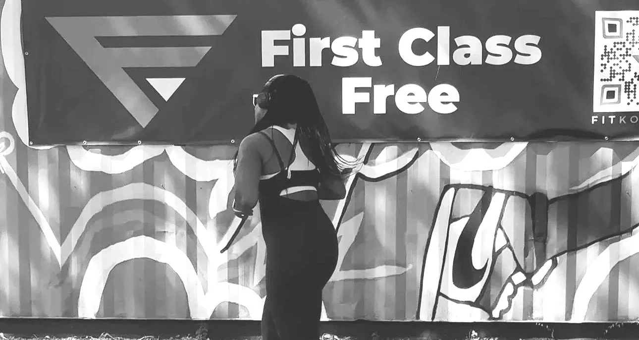 A FitKonnekt member in front of the First Class Free banner at Boxville in Bronzeville, Chicago