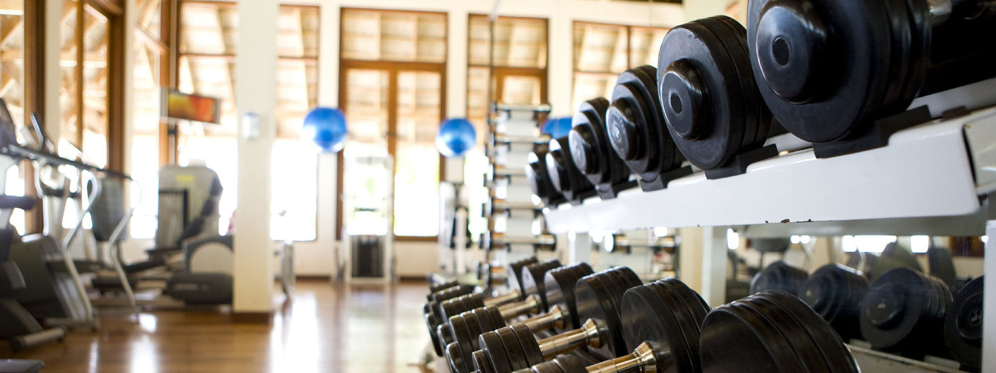 Fitness Equipment Broker gym interior with dumbbell rack and cardio equipment