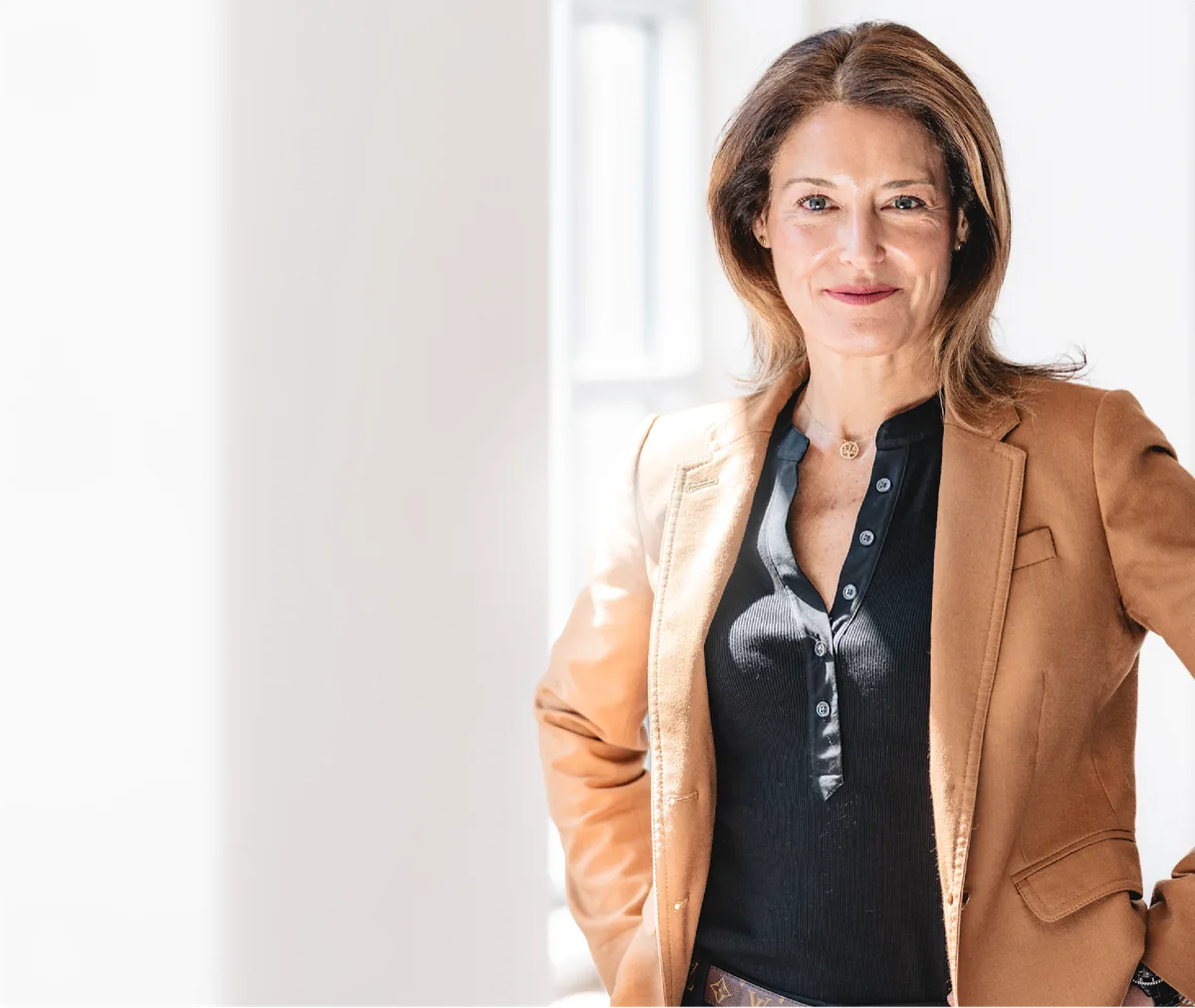 Megan Dittman, founder of Front Goose Wellbeing, in a camel blazer in a bright studio