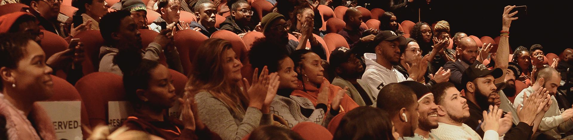 A large audience applauding in a theater