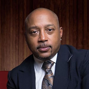 Portrait of Daymond John in a navy suit