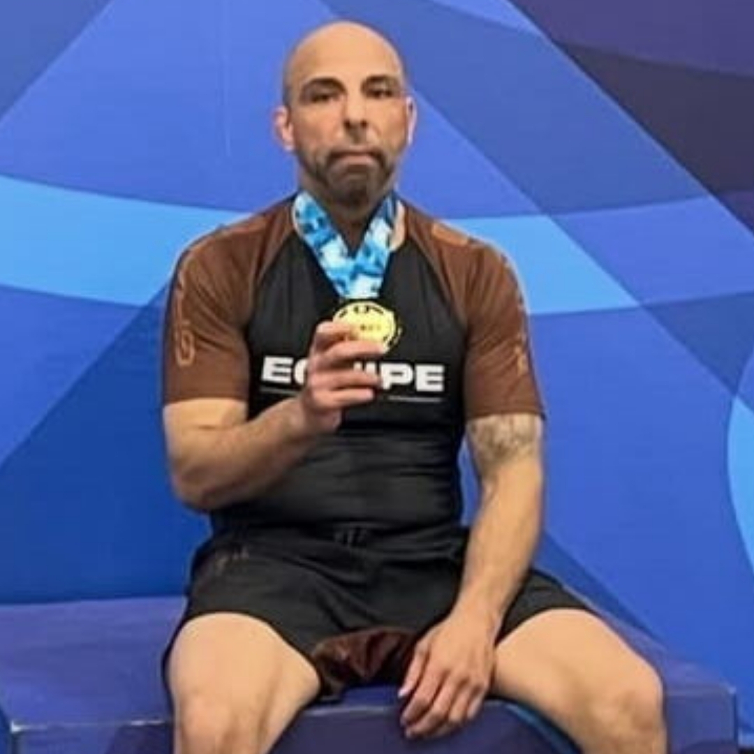 Johnny Saadeh in a brown Equipe rash guard with a gold competition medal