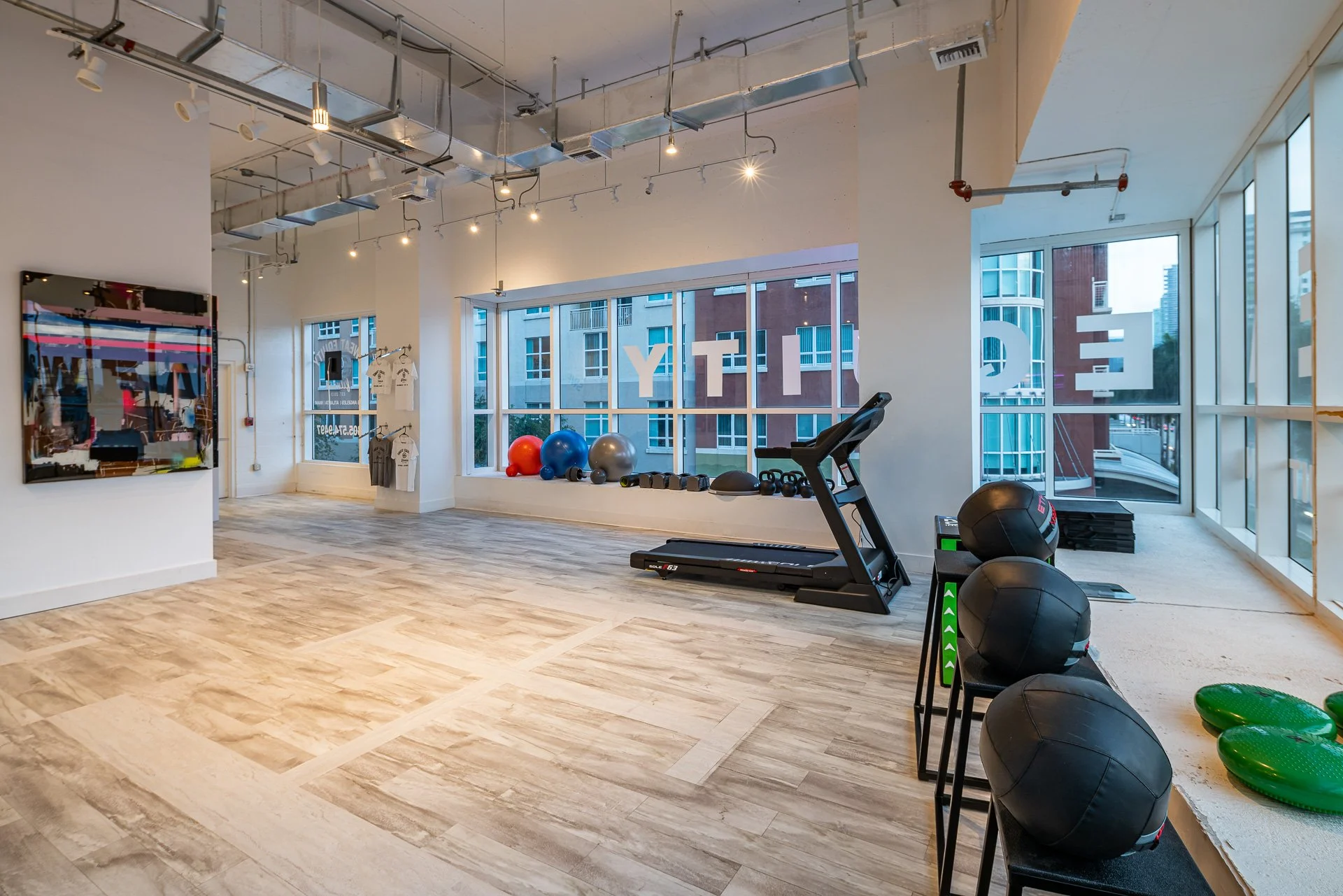 Bright open gym floor at Sweat Equity Fitness with treadmill and medicine balls