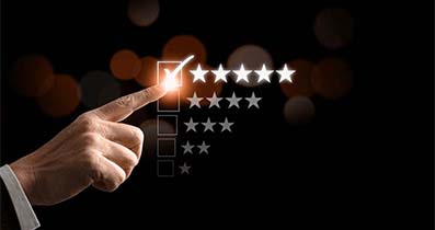 A hand touching a glowing five-star rating