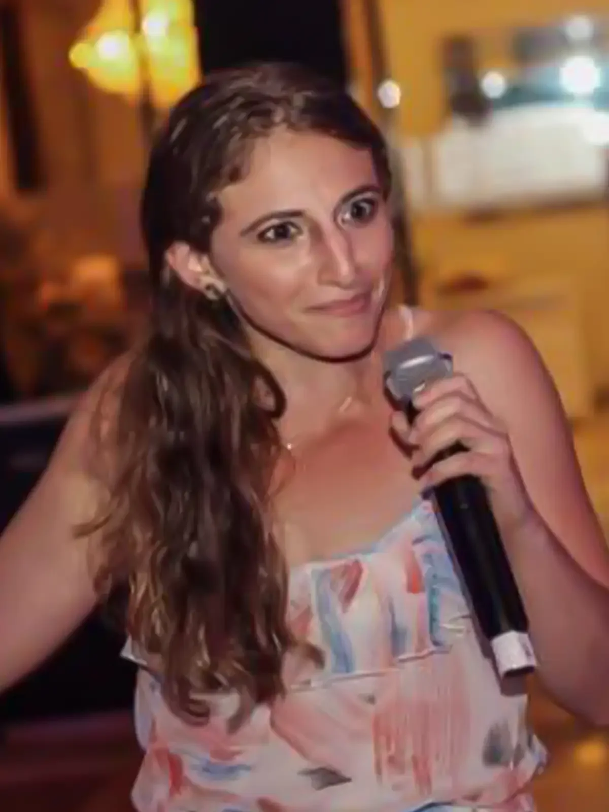 Rebecca Lehman, holding a microphone at an event