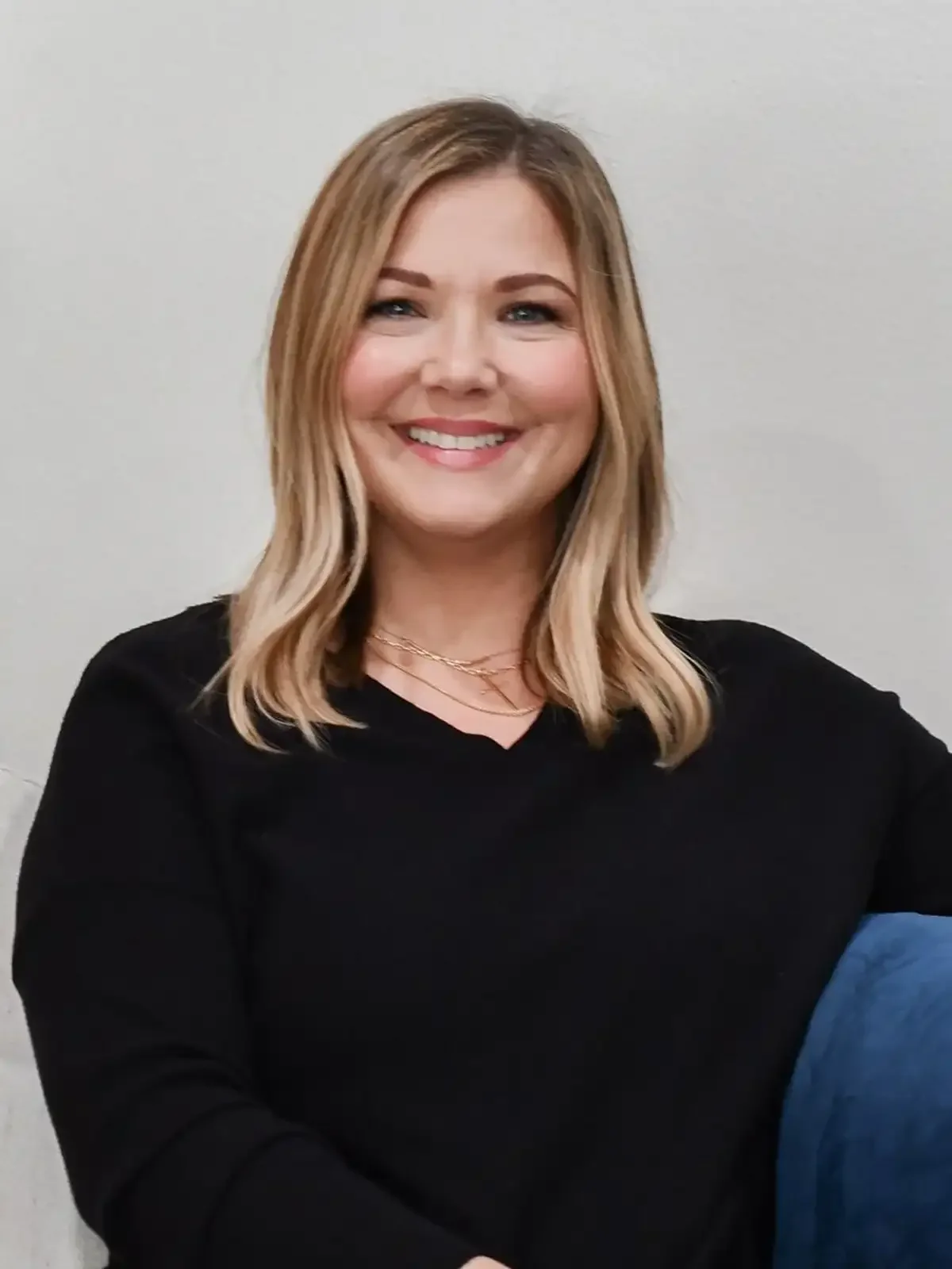 Amy Bridges, smiling, blonde in a black sweater