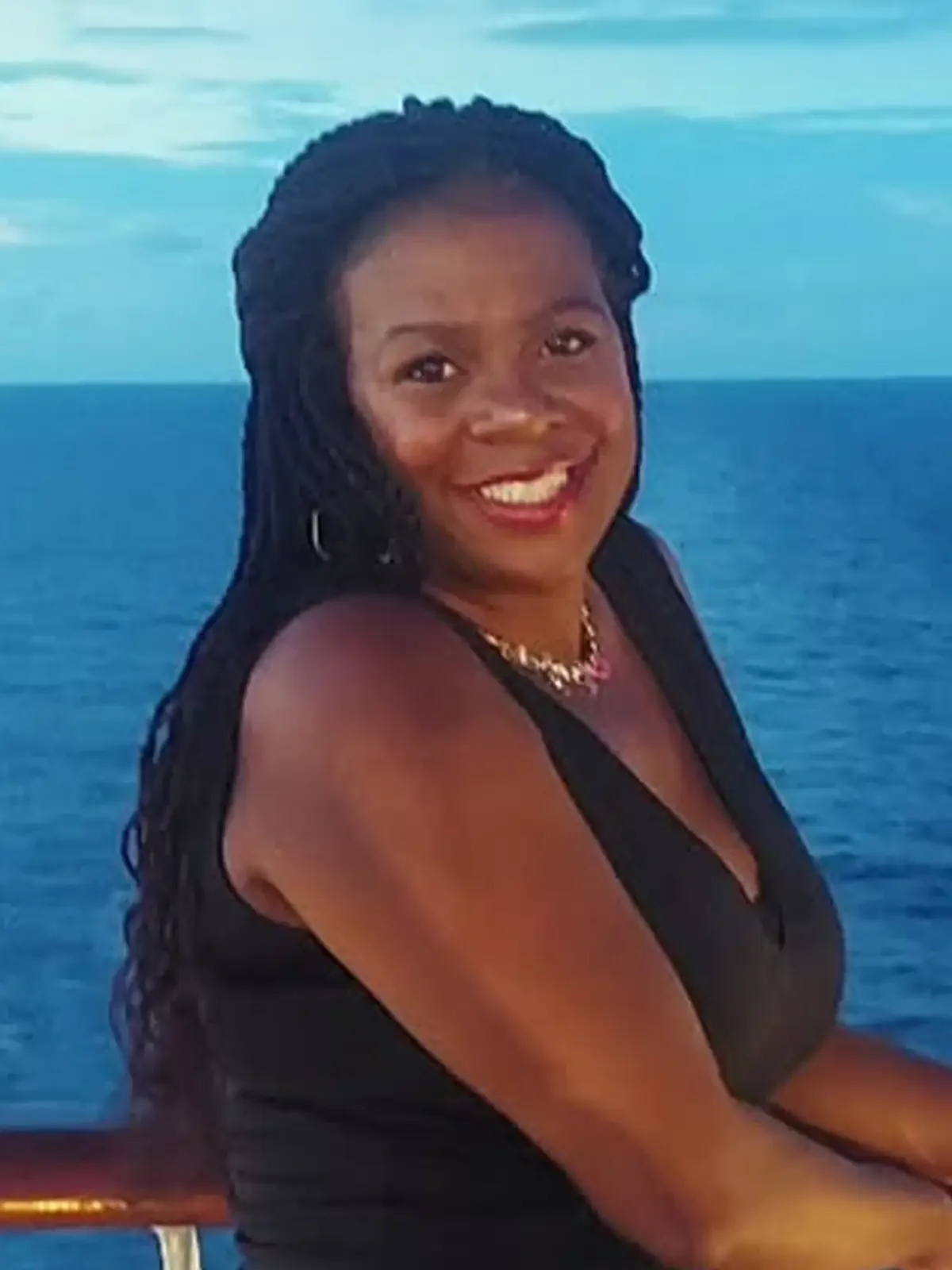 Tasha Pitchford, smiling with braided hair on an ocean deck