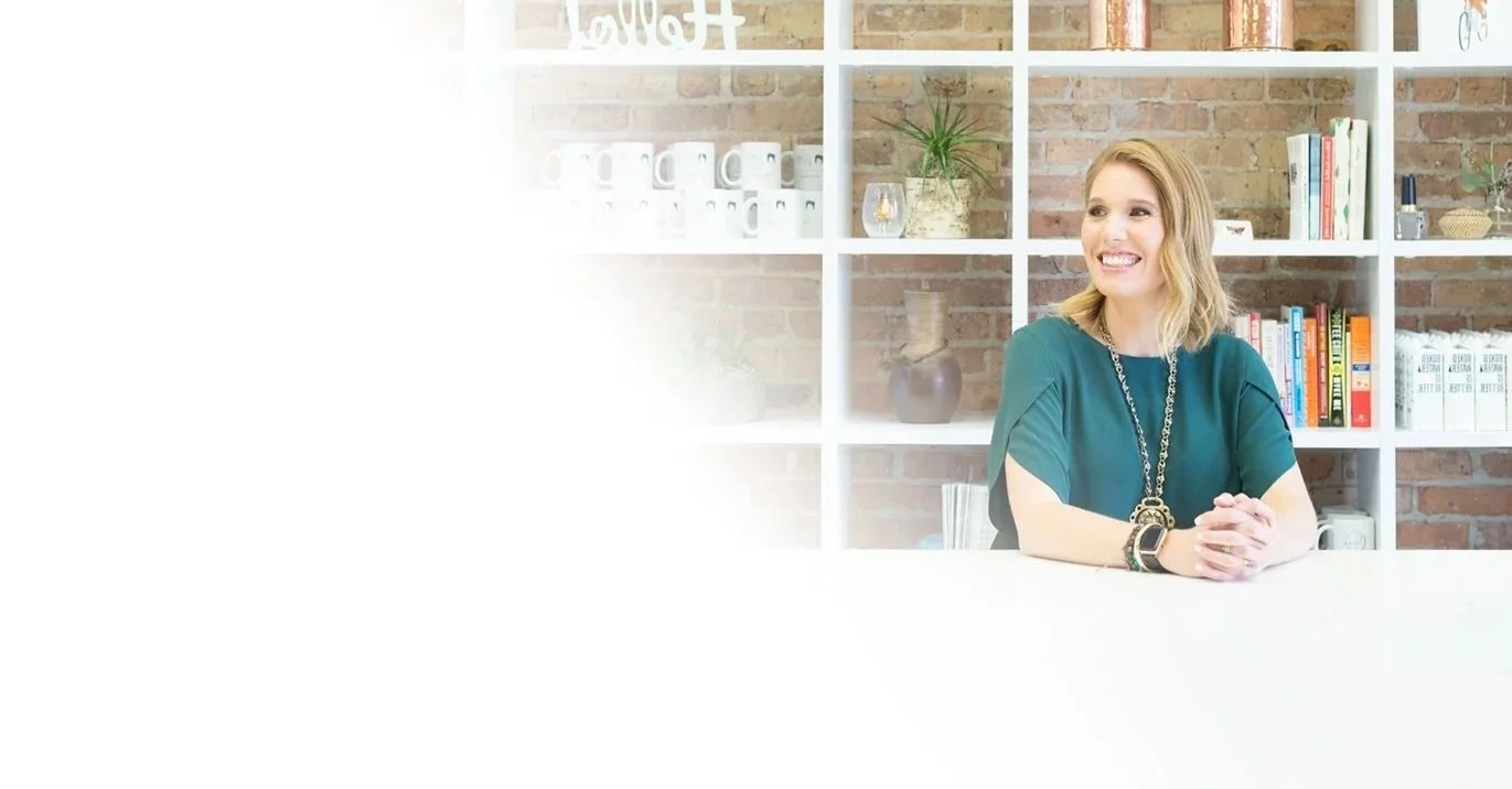 Karianne Michelle, Lofti founder, seated at her desk in front of a bookshelf and exposed brick wall