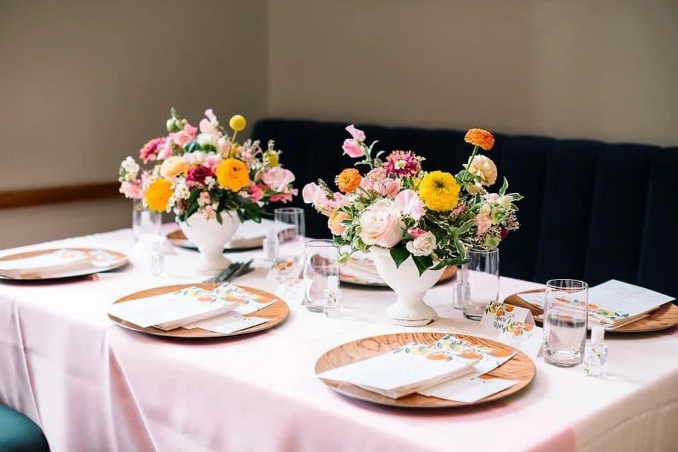 Bridal shower luncheon table with yellow and pink floral centerpieces