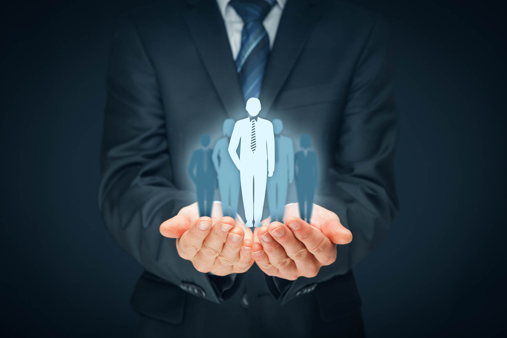 Businessman holding glowing silhouettes of a team in his cupped hands