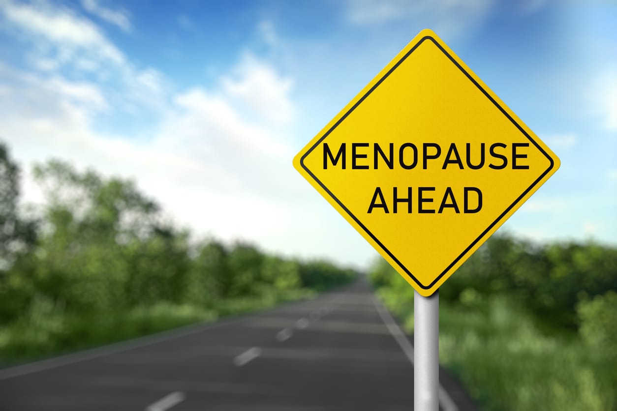 Yellow road sign reading Menopause Ahead