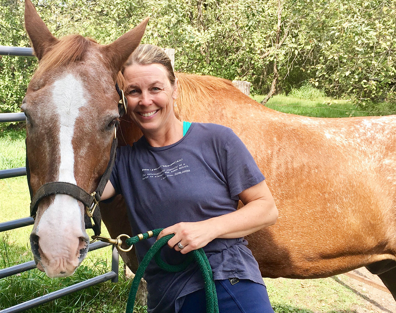 Sarah Haberman smiling cheek-to-cheek with a brown horse